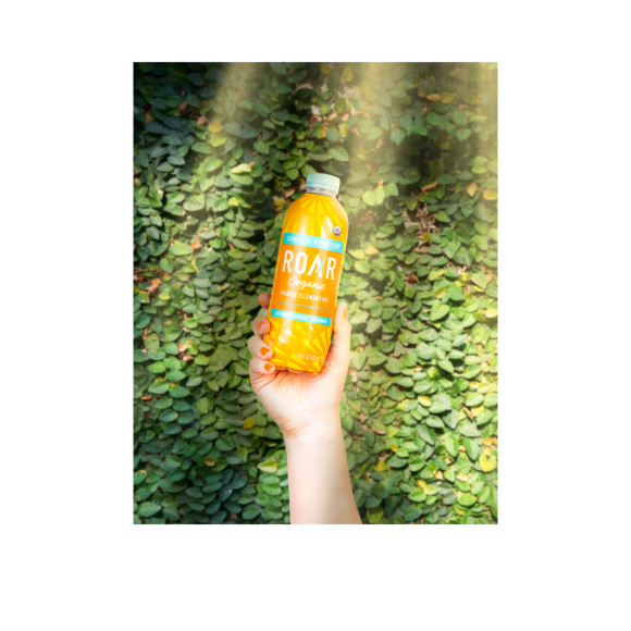 hand holding a bottle of roar organic mango clementine drink Image2