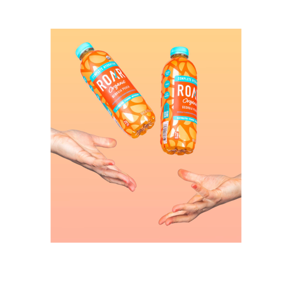 hands throwing bottles of roar organic georgia peach drinks Image2